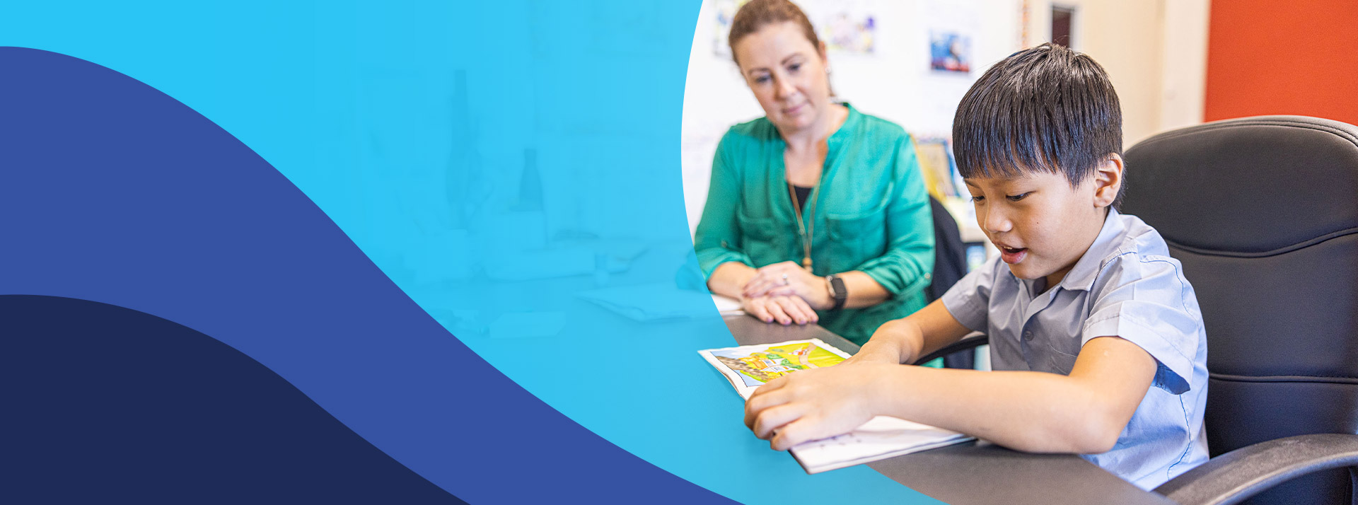 Teacher reading with her student in the classroom at St John's Primary School Riverstone