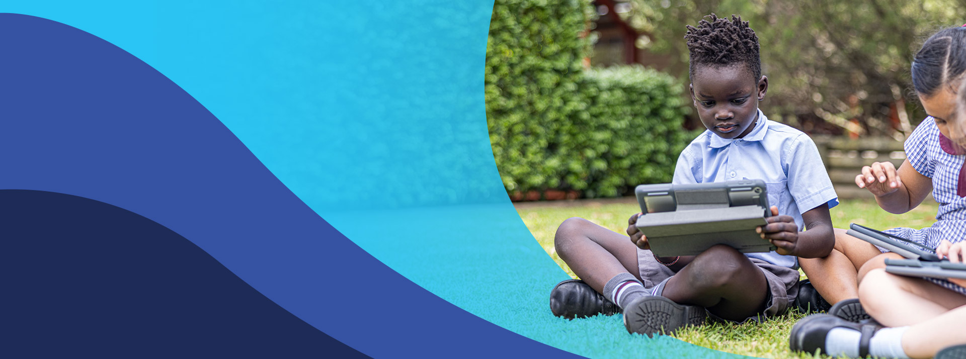 Students working together on their tablets on the grass at St John's Primary School Riverstone