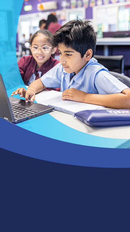 Students working together on the laptop in the classroom at St John's Primary School Riverstone