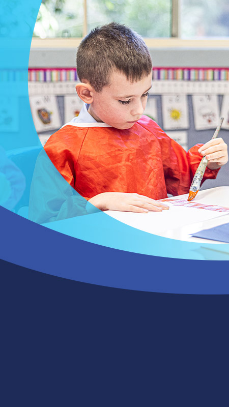 Student painting in the classroom at St John's Primary School Riverstone