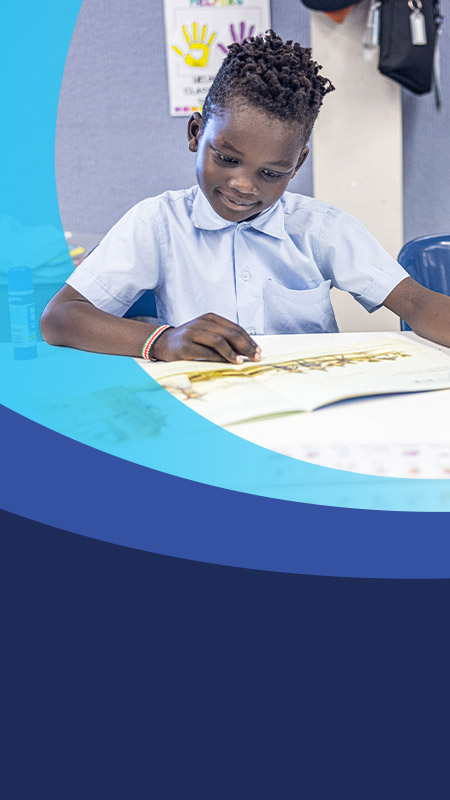 Student reading a book in the classroom at St John's Primary School Riverstone