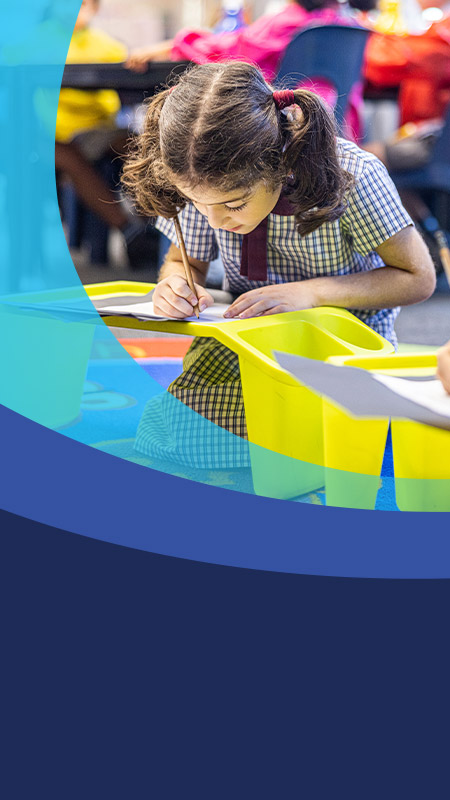 Student writing in the classroom at St John's Primary School Riverstone