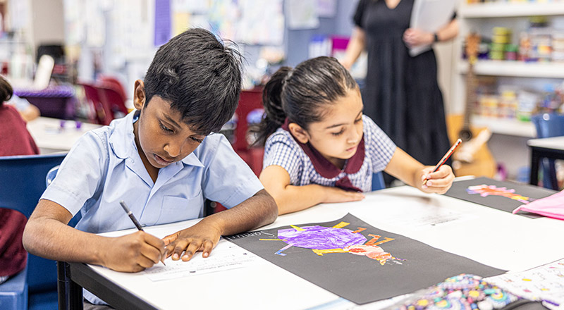 Students writing at their desk in the classroom at St John's Primary School Riverstone