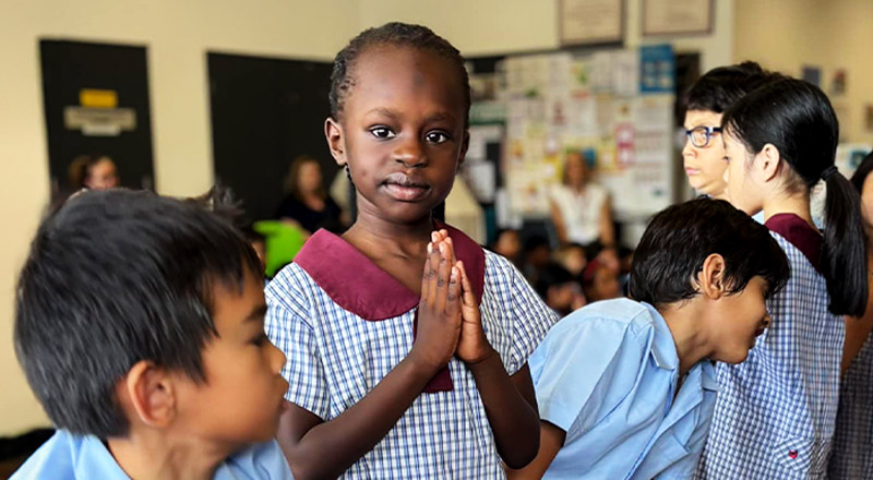 Student in prayer during a school event at St John's Primary School Riverstone