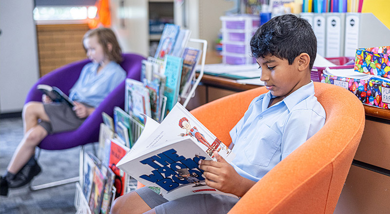Student reading in the library at St John's Primary School Riverstone