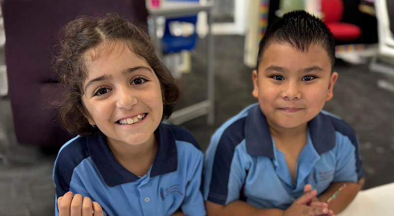 Students smiling in the classroom at St John's Primary School Riverstone