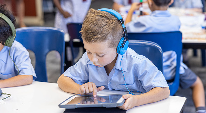 Student using his tablet in the classroom at St John's Primary School Riverstone