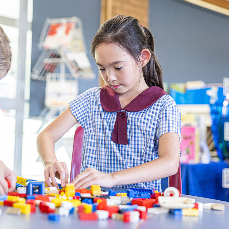Student building with lego in Before and After school care at St John's Primary School Riverstone