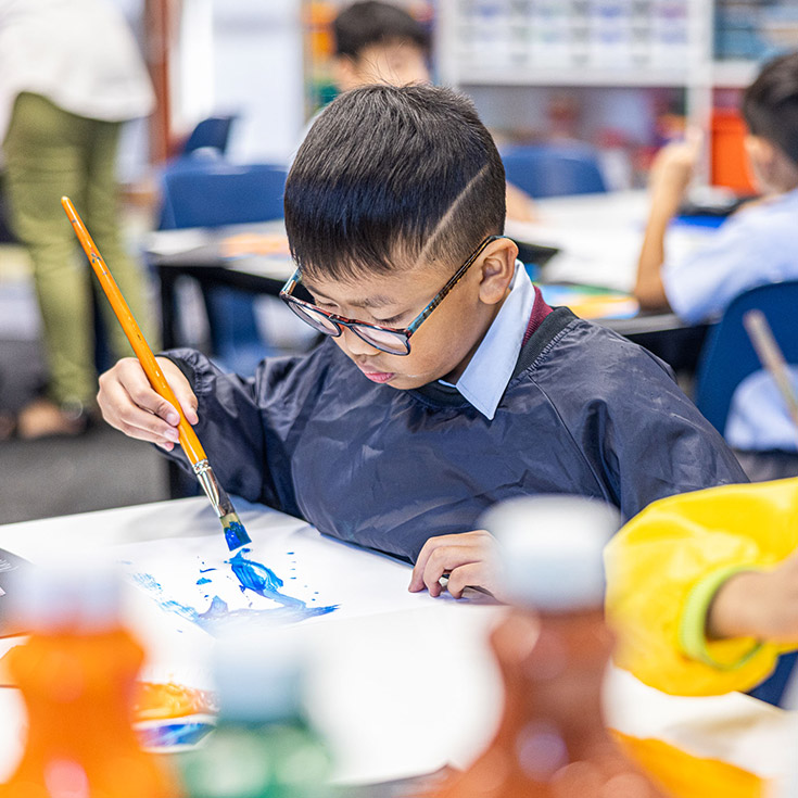 Student painting in the classroom at St John's Primary School Riverstone