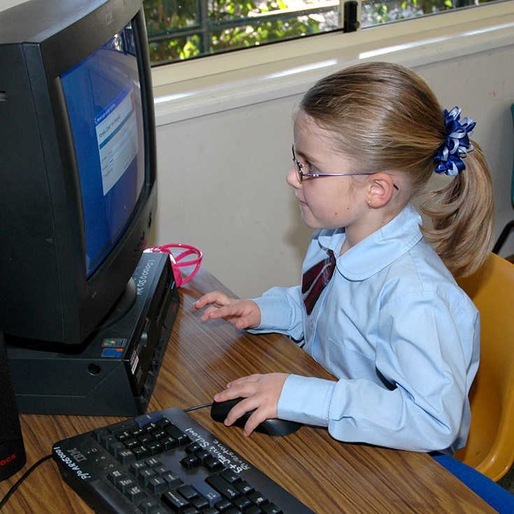 Student using a desktop computer in the classroom at St John's Primary School Riverstone in 2006