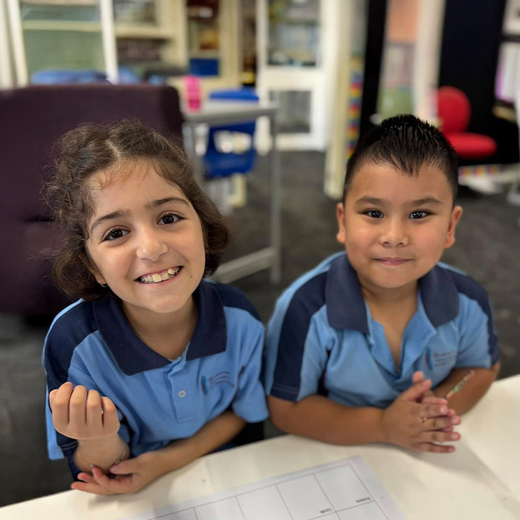 Students smiling in the classroom at St John's Primary School Riverstone