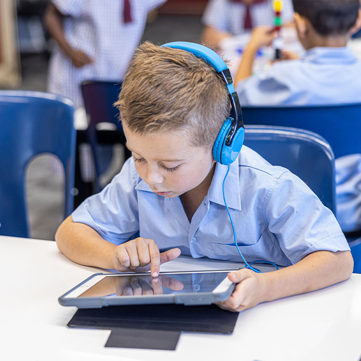 Student using his tablet in the classroom at St John's Primary School Riverstone