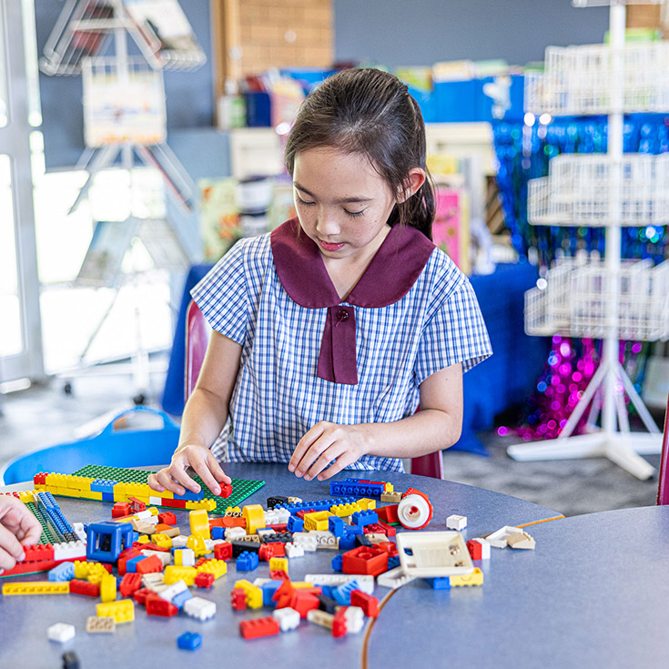 Student building with lego in Before and After school care at St John's Primary School Riverstone